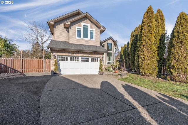 view of front of house with a shingled roof, concrete driveway, fence, a garage, and stone siding