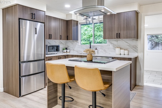 3711 N Alaska Pl, Portland, OR 97217 - kitchen featuring appliances with stainless steel finishes, a kitchen breakfast bar, a sink, light countertops, and tasteful backsplash