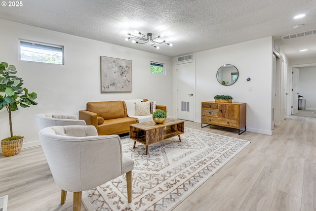 3711 N Alaska Pl, Portland, OR 97217 - living room featuring light wood-style floors, baseboards, plenty of natural light, and a textured ceiling