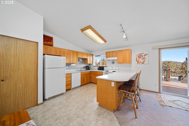 kitchen featuring a kitchen breakfast bar, a healthy amount of sunlight, sink, and white appliances