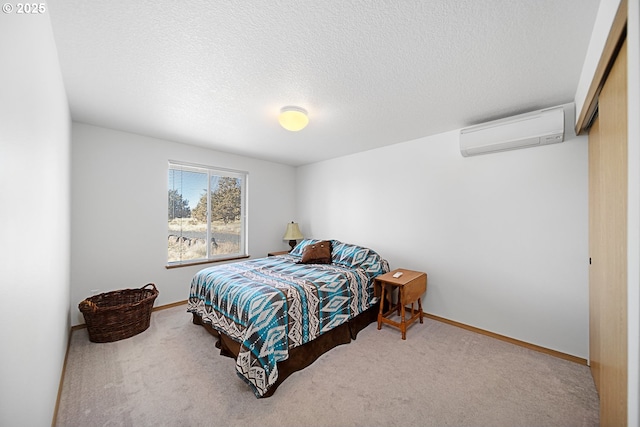 bedroom featuring carpet flooring, a wall mounted air conditioner, a textured ceiling, and a closet