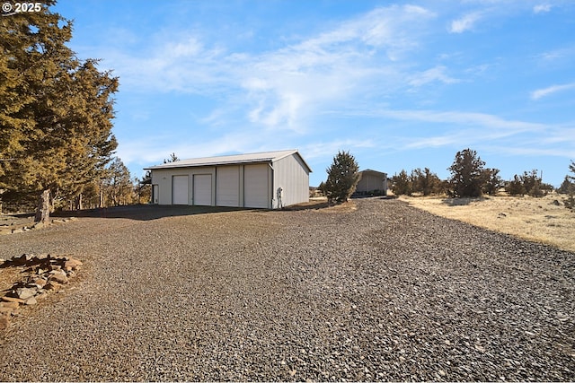 exterior space with a garage and an outbuilding