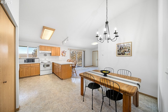 kitchen featuring pendant lighting, white electric range oven, kitchen peninsula, and a notable chandelier