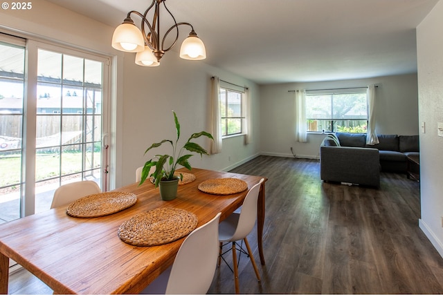 dining space featuring dark wood-style floors, baseboards, and a chandelier