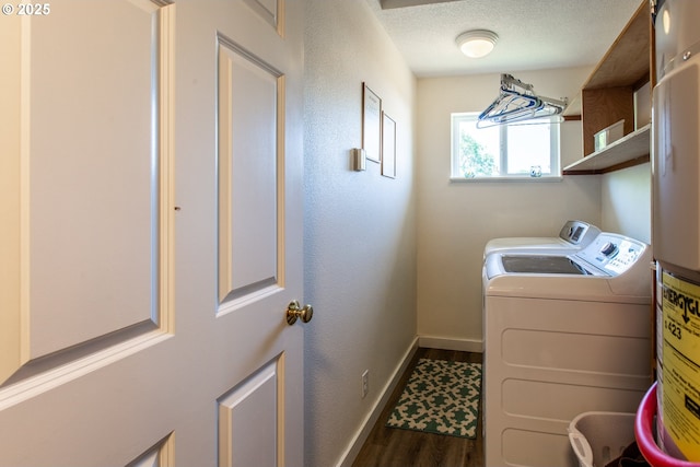 clothes washing area featuring dark wood-style flooring, washing machine and dryer, baseboards, and water heater