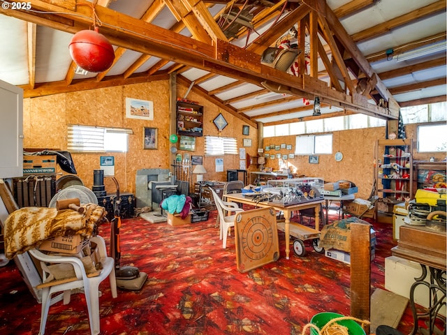 dining space featuring a workshop area and vaulted ceiling with beams