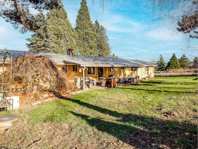 rear view of property featuring a lawn