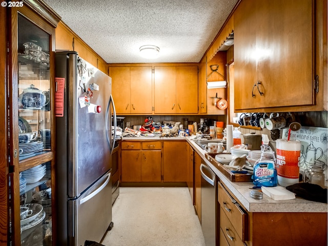 kitchen with sink, a textured ceiling, and appliances with stainless steel finishes