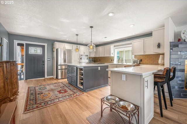 460 N Tomahawk Island Dr, Portland, OR 97217 - kitchen featuring appliances with stainless steel finishes, white cabinetry, light wood-type flooring, recessed lighting, and a textured ceiling