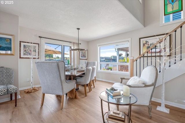 460 N Tomahawk Island Dr, Portland, OR 97217 - dining area with wood finished floors, stairs, and a textured ceiling