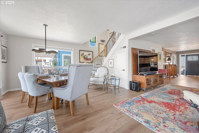 460 N Tomahawk Island Dr, Portland, OR 97217 - dining area featuring a textured ceiling, wood finished floors, and stairs