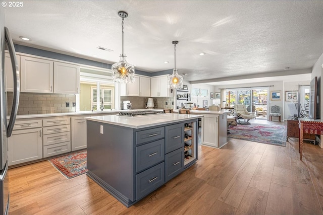 460 N Tomahawk Island Dr, Portland, OR 97217 - kitchen with open floor plan, a center island, light countertops, a textured ceiling, and healthy amount of natural light