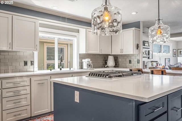 460 N Tomahawk Island Dr, Portland, OR 97217 - kitchen featuring stainless steel gas cooktop, a kitchen island, white cabinets, backsplash, and recessed lighting