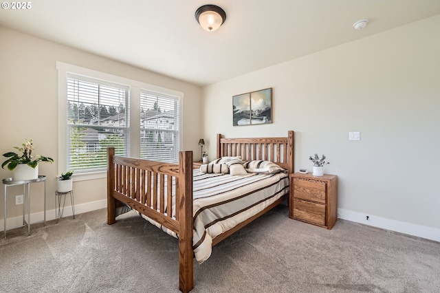 carpeted bedroom featuring multiple windows and baseboards