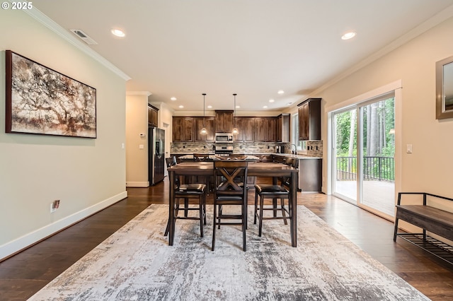 dining room with ornamental molding, recessed lighting, dark wood-type flooring, and baseboards