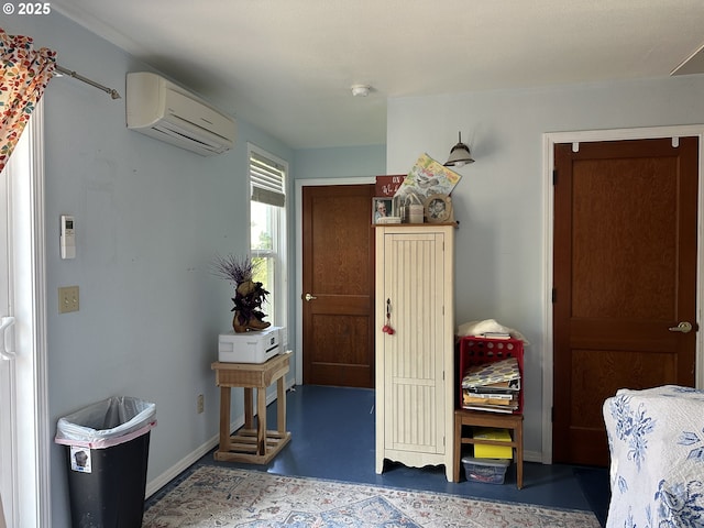 bedroom with a wall mounted air conditioner, finished concrete floors, and baseboards