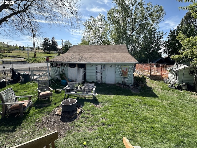 view of yard with an outdoor fire pit and an outbuilding