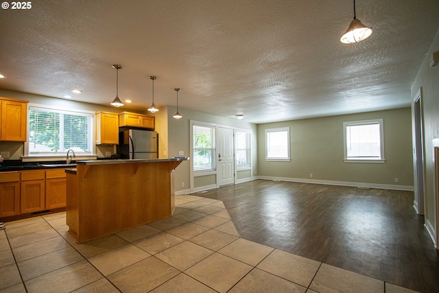 1072 53rd St, Springfield, OR 97478 - kitchen featuring freestanding refrigerator, a sink, a textured ceiling, open floor plan, and dark countertops