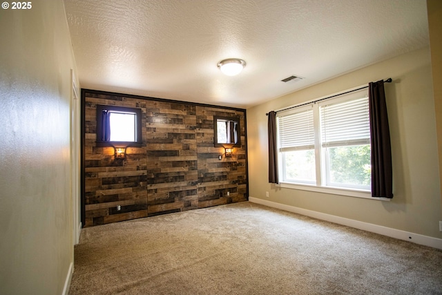 1072 53rd St, Springfield, OR 97478 - spare room featuring plenty of natural light, carpet floors, an accent wall, wooden walls, and a textured ceiling