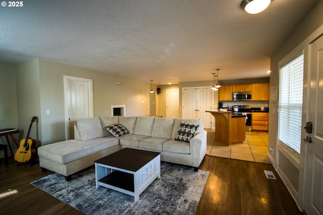 1072 53rd St, Springfield, OR 97478 - living area with light wood-style floors, visible vents, a textured ceiling, and baseboards