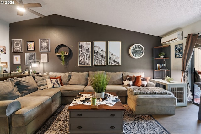 living room featuring vaulted ceiling, wood finished floors, a wall mounted air conditioner, and a textured ceiling