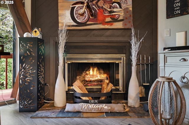 details featuring a glass covered fireplace, wood finished floors, and wood walls