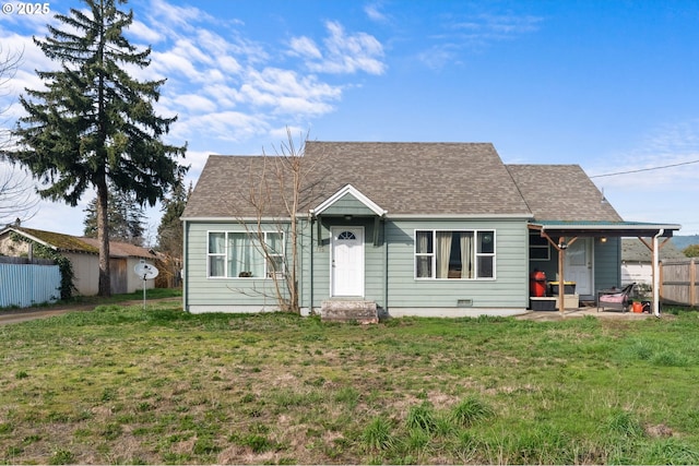 view of front of house featuring crawl space, a shingled roof, fence, and a front lawn