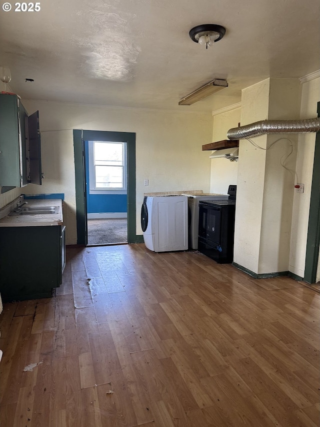 laundry area featuring a sink, washer / clothes dryer, and wood finished floors