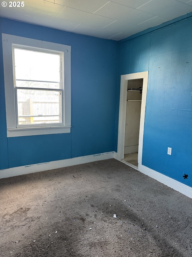 unfurnished room with baseboards