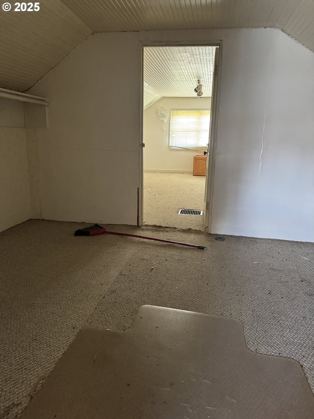 additional living space featuring lofted ceiling, carpet flooring, and visible vents