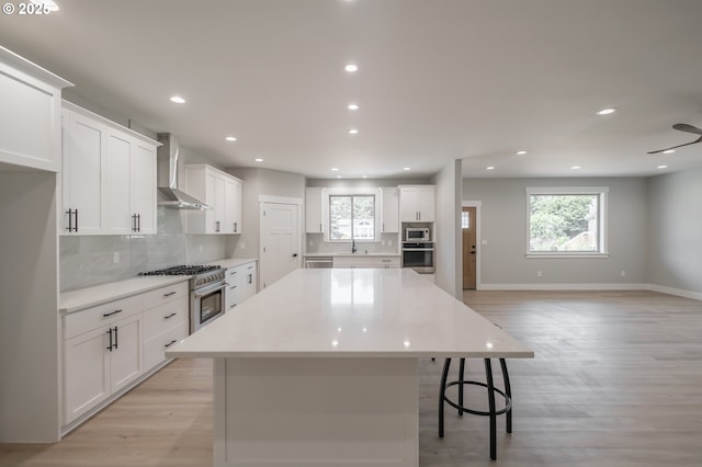 7320 Tanglewood Ave, Gleneden Beach, OR 97388 - kitchen featuring wall chimney range hood, stainless steel appliances, decorative backsplash, a center island, and recessed lighting