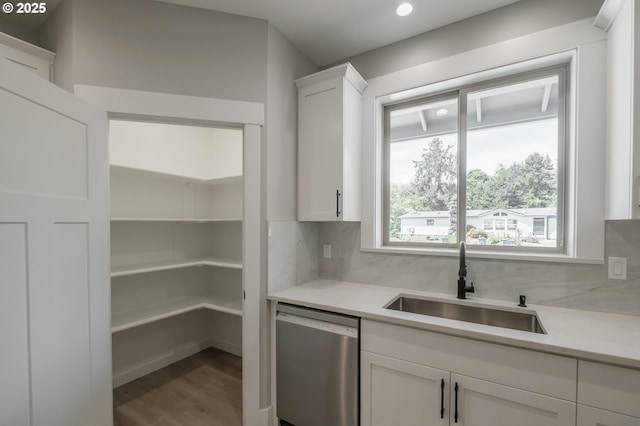 7320 Tanglewood Ave, Gleneden Beach, OR 97388 - kitchen featuring stainless steel dishwasher, white cabinetry, decorative backsplash, wood finished floors, and light countertops