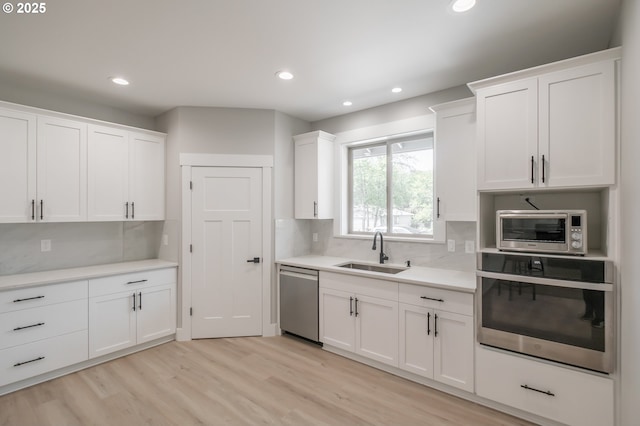 7320 Tanglewood Ave, Gleneden Beach, OR 97388 - kitchen featuring stainless steel appliances, white cabinetry, light countertops, recessed lighting, and tasteful backsplash