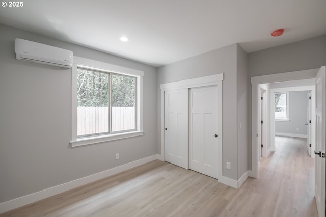 7320 Tanglewood Ave, Gleneden Beach, OR 97388 - unfurnished bedroom featuring a wall mounted AC, light wood-style flooring, recessed lighting, and a closet