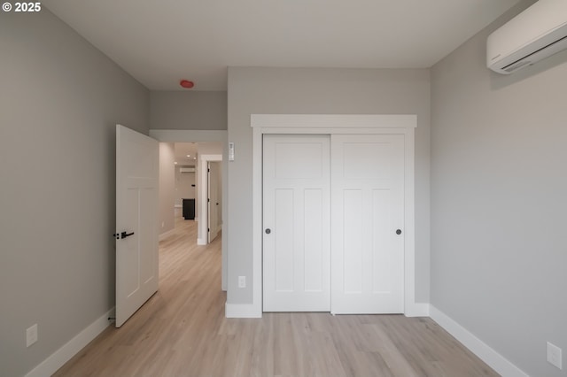 7320 Tanglewood Ave, Gleneden Beach, OR 97388 - unfurnished bedroom with an AC wall unit, light wood-style floors, and a closet
