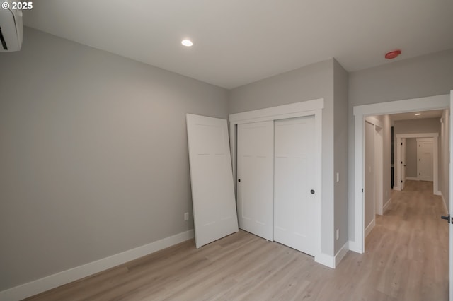 7320 Tanglewood Ave, Gleneden Beach, OR 97388 - unfurnished bedroom with a wall unit AC, light wood finished floors, recessed lighting, and a closet