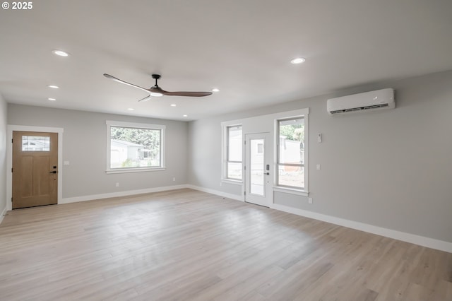7320 Tanglewood Ave, Gleneden Beach, OR 97388 - unfurnished living room featuring a wall unit AC, a ceiling fan, plenty of natural light, light wood-style floors, and recessed lighting