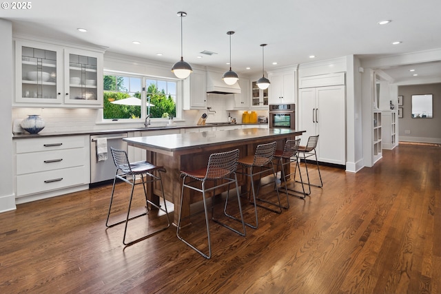 17900 Crestline Dr, Lake Oswego, OR 97034 - kitchen featuring appliances with stainless steel finishes, dark countertops, a kitchen bar, a center island, and decorative backsplash