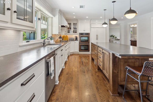 17900 Crestline Dr, Lake Oswego, OR 97034 - kitchen featuring appliances with stainless steel finishes, a sink, dark countertops, dark wood-style floors, and glass insert cabinets