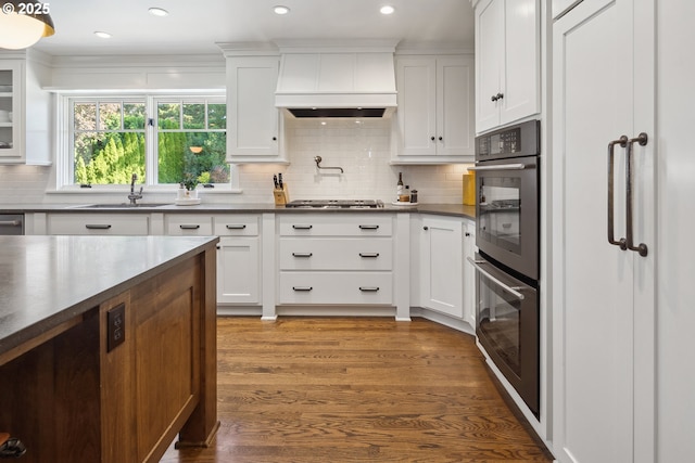 17900 Crestline Dr, Lake Oswego, OR 97034 - kitchen featuring custom exhaust hood, dark countertops, a sink, multiple ovens, and stainless steel gas stovetop