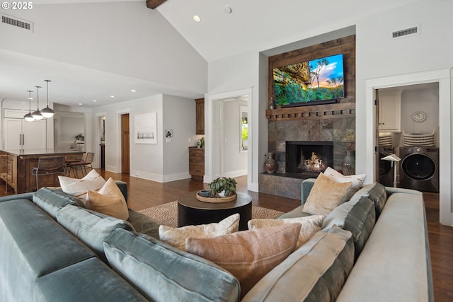 17900 Crestline Dr, Lake Oswego, OR 97034 - living area with separate washer and dryer, dark wood finished floors, high vaulted ceiling, a stone fireplace, and beam ceiling
