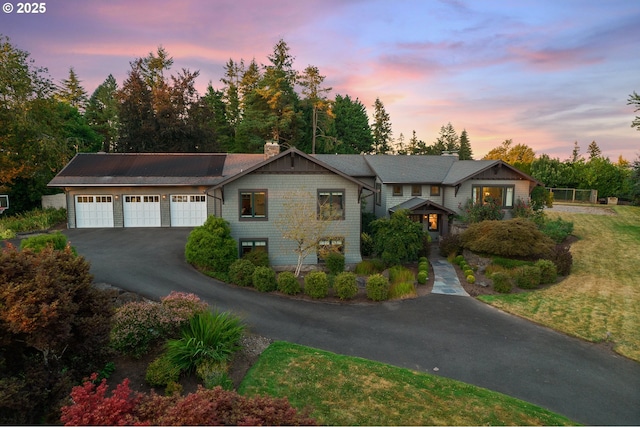 17900 Crestline Dr, Lake Oswego, OR 97034 - view of front of home with asphalt driveway, a chimney, roof mounted solar panels, and a garage