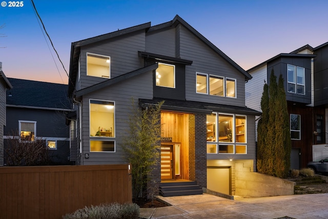 contemporary home with brick siding and fence