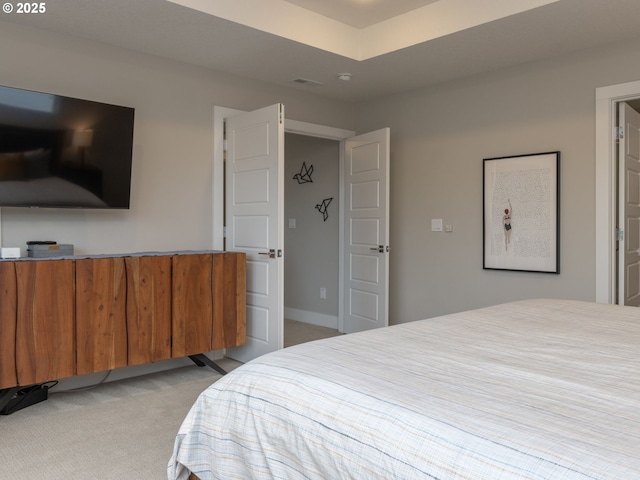 bedroom featuring baseboards and light colored carpet