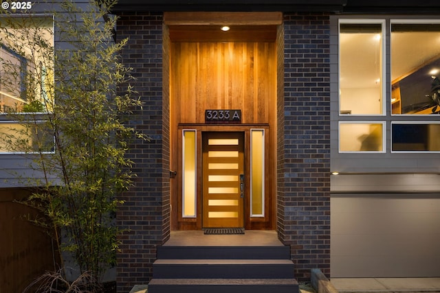 entrance to property featuring brick siding