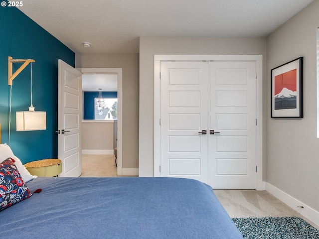 carpeted bedroom with baseboards and a closet