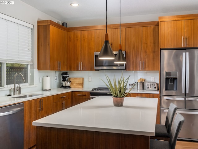 kitchen with light countertops, appliances with stainless steel finishes, backsplash, and a sink