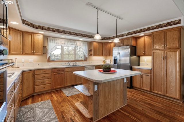 kitchen featuring a kitchen island, dark wood-style flooring, light countertops, stainless steel refrigerator with ice dispenser, and a sink