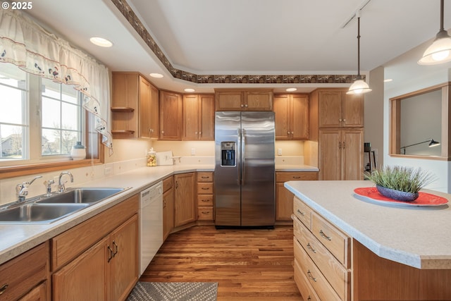 kitchen with white dishwasher, a sink, light countertops, stainless steel refrigerator with ice dispenser, and light wood finished floors