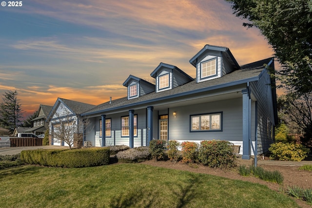 cape cod-style house with an attached garage, a front lawn, and concrete driveway